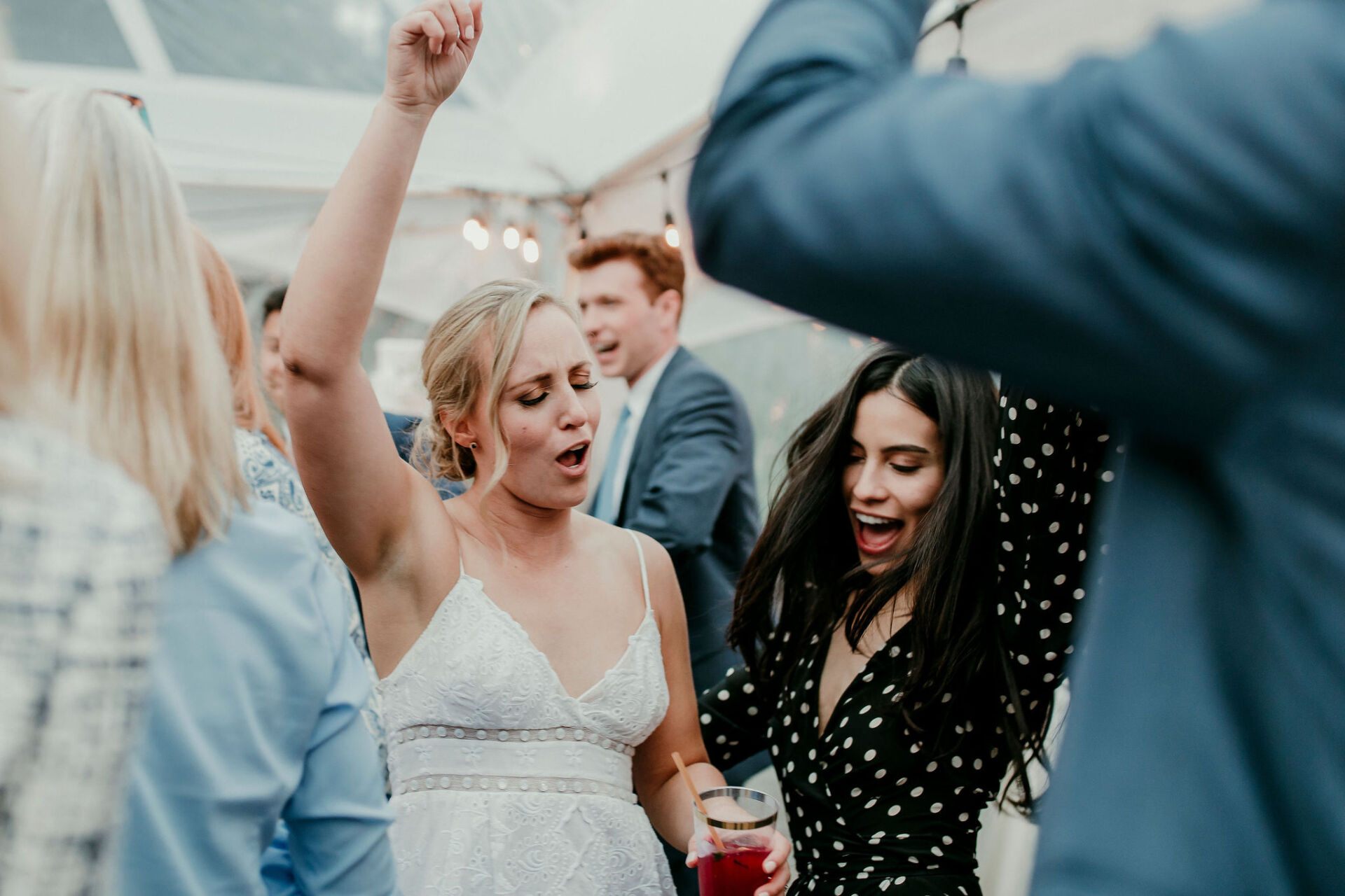302 Bride singing along with friends on the dance floor of a tented Alaska wedding reception