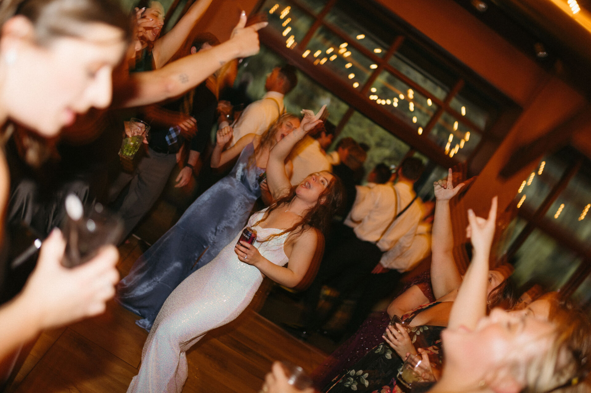 Goodhart Wedding Packed dance floor of guests dancing under string lights late in an Alaska wedding reception